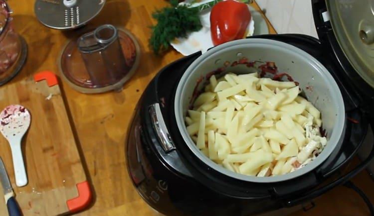 Nous coupons des pommes de terre et les ajoutons également dans le bol multicuiseur.