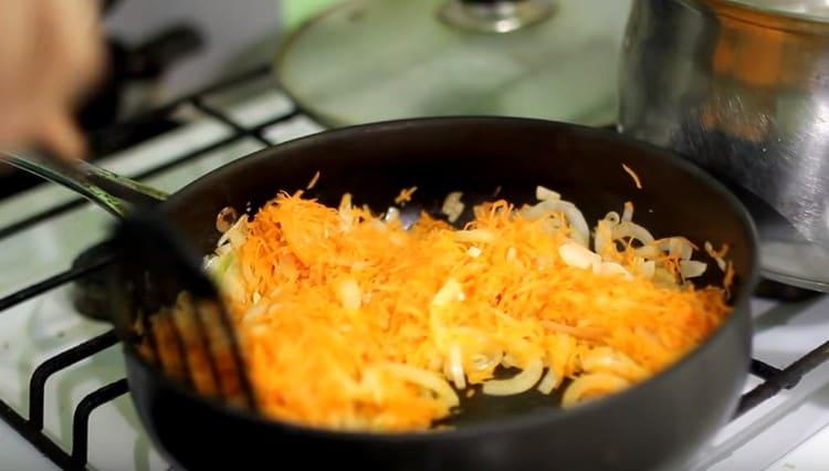 Agregue las zanahorias ralladas en un rallador grueso a la cebolla y al pasador.