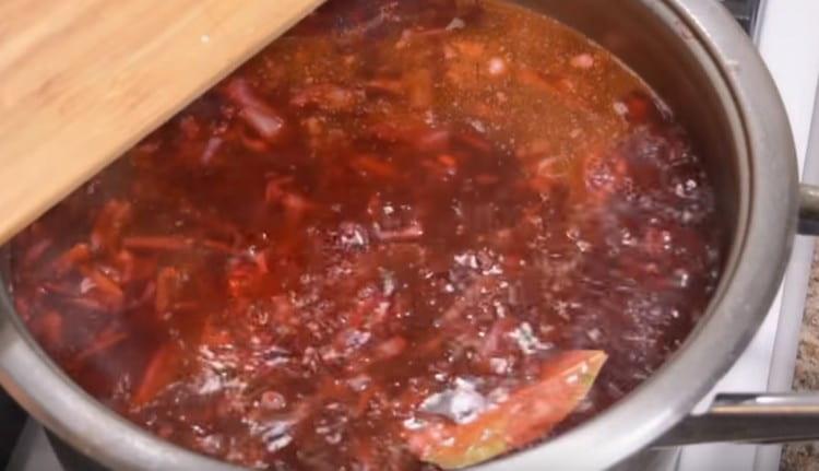At the end of cooking, add bay leaf, salt, and chopped garlic to the borsch.