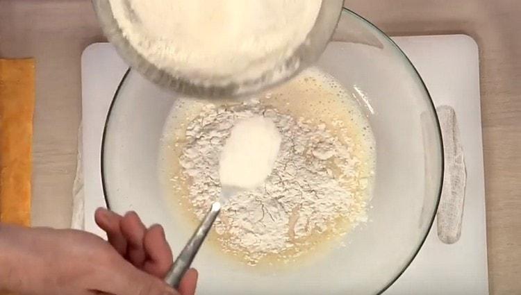 Agregue harina y levadura seca a la mezcla de huevo y leche.