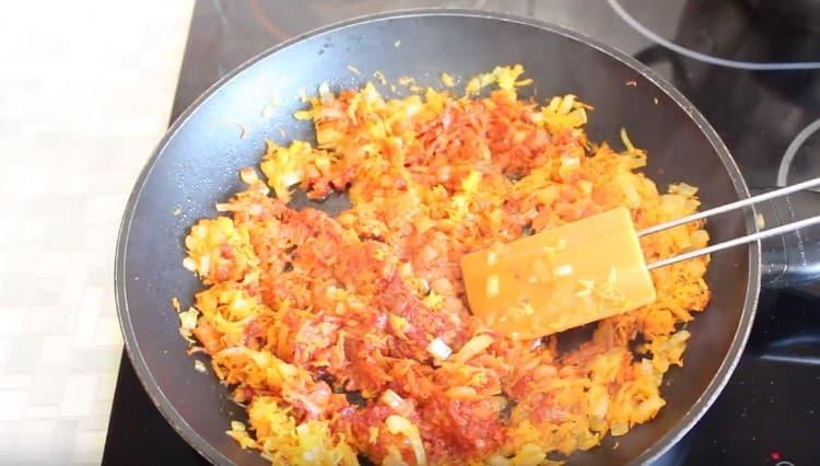 Agregue la pasta de tomate a las cebollas con zanahorias.