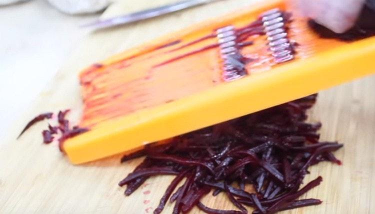 three beets on a grater, as well as carrots.