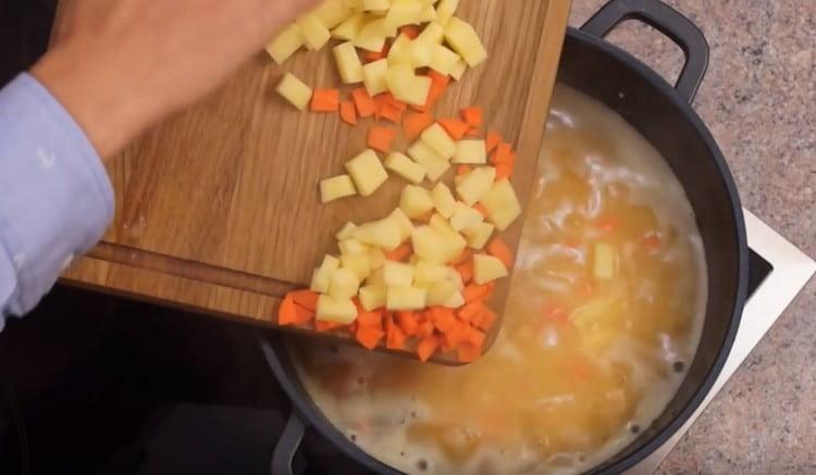 Agregue zanahorias y papas a la sopa.