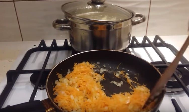 Add grated carrots to the onion in the pan.