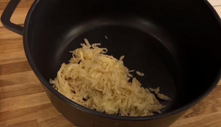 Râpez les pommes de terre et mettez-les dans un récipient profond pour la cuisson de la viande hachée.