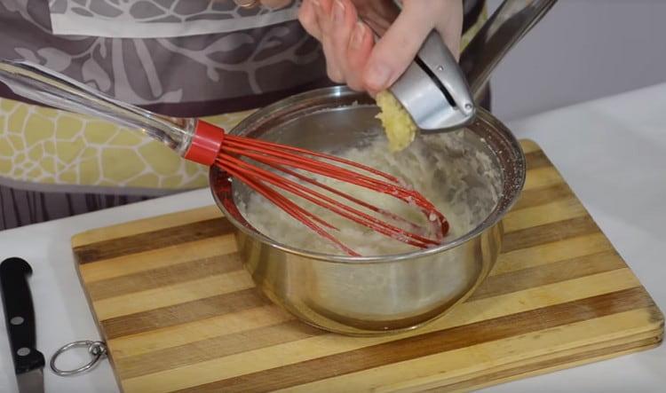 Presser une gousse d'ail dans la pâte.