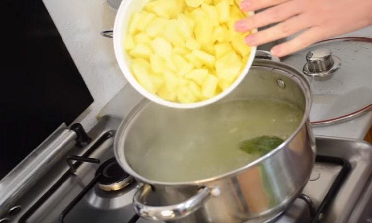 Nous envoyons des pommes de terre dans un bouillon bouillant.