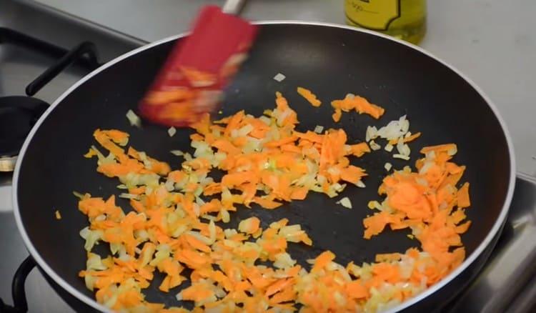 Agregue zanahorias a la cebolla y prepare la fritura.