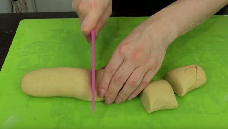 Étaler une saucisse de chaque morceau de pâte et la diviser en 5 morceaux identiques.