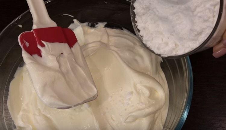 Pour préparer la crème, mélangez la crème sure au sucre en poudre.