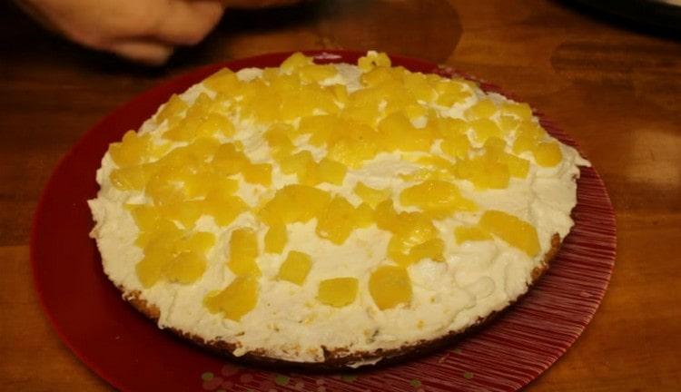Graisser la première partie du gâteau avec de la crème et saupoudrer d'ananas.