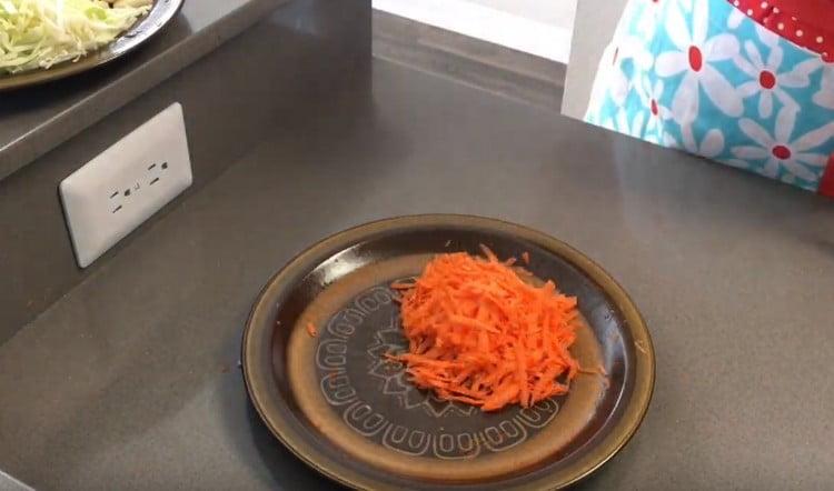 On a coarse grater, three carrots.