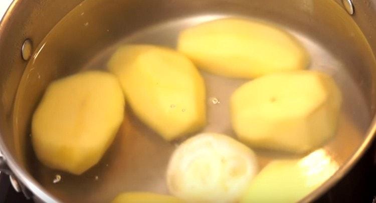 Ajoutez les pommes de terre dans la casserole, ajoutez la tête d'oignon et remplissez avec de l'eau.