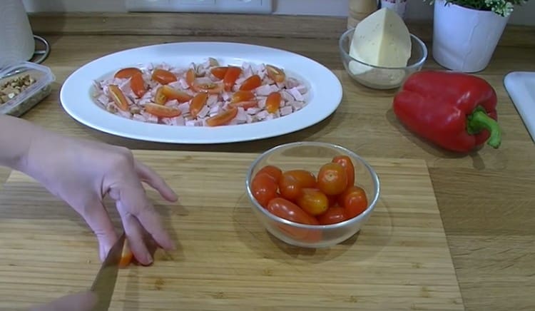 Cherry rajčice narežemo na četvrtine i ravnomjerno ih rasporedimo po piletini.