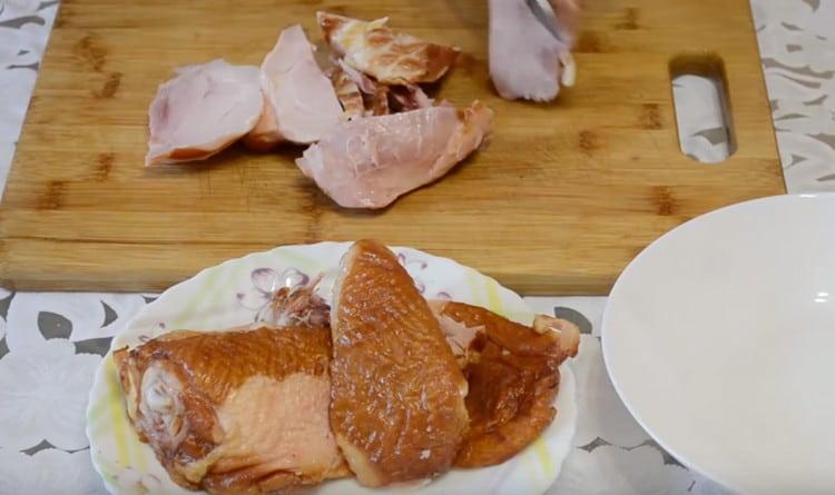 Quitamos la piel de los muslos de pollo ahumados y separamos la carne del hueso.