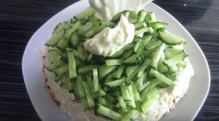 We make a cucumber layer, which is also covered with garlic sauce.