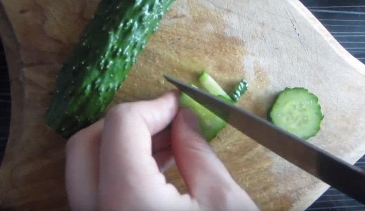 Les pailles coupent un concombre frais.