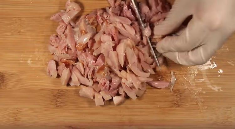 Nous retirons la peau des cuisses de poulet et coupons la viande en morceaux.