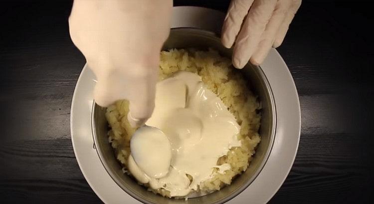 Širimo prvi sloj krumpira u salati, namažemo ga majonezom.