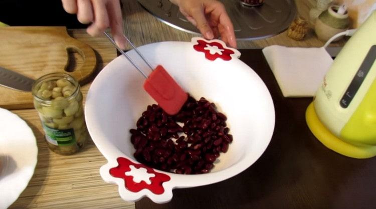 Escurra el agua enlatada de los frijoles y transfiérala a la ensaladera.