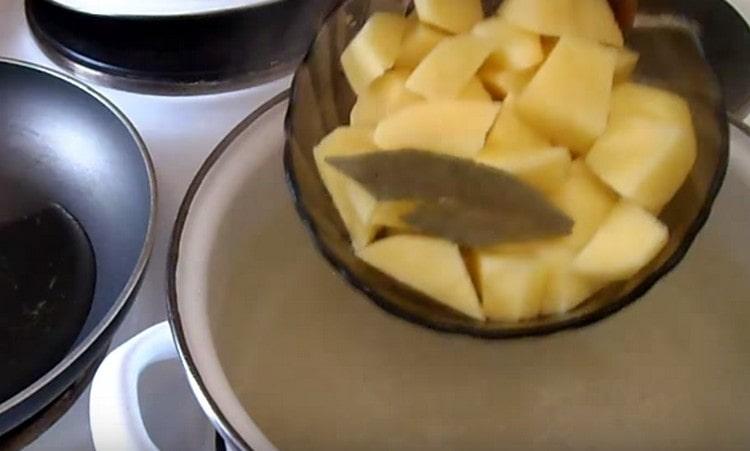 Du riz et des pommes de terre avec des feuilles de laurier sont envoyés à la poêle.