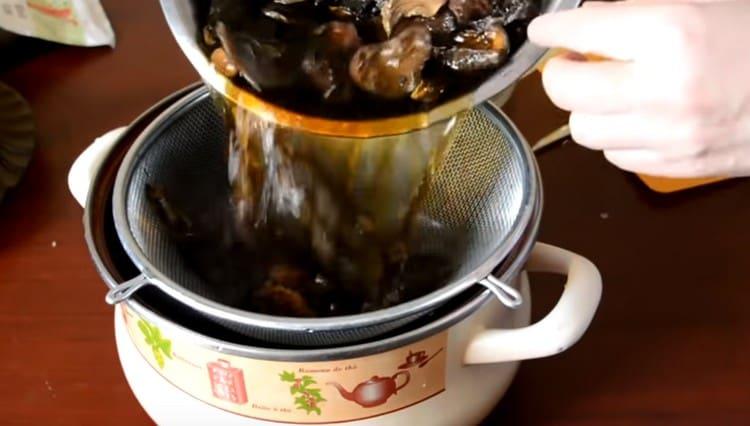 Cuando los champiñones se ablandan, los descartamos en un tamiz y dejamos el agua para preparar la sopa.