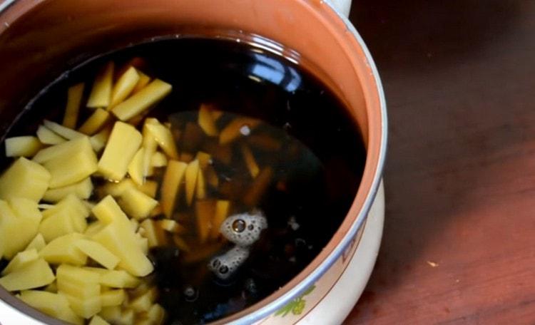 Ponga las papas en una olla con agua debajo de los hongos, agregue más agua y prende fuego.