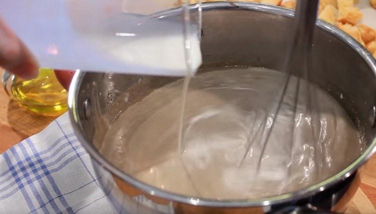 Enter the cream into the soup, stirring it with a whisk.