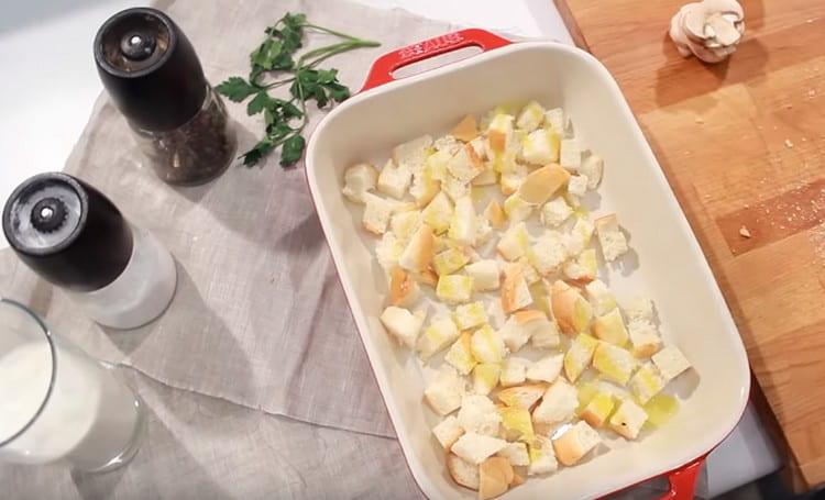 Cambiamos los trozos de baguette en una fuente para horno, espolvoreamos con aceite vegetal y los enviamos al horno.