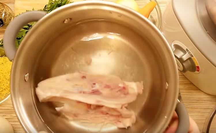 Verser l'os de poitrine de poulet dans une casserole avec de l'eau et mettre à ébullition.