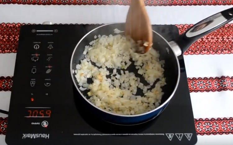 Fry chopped onions in a pan with vegetable oil.