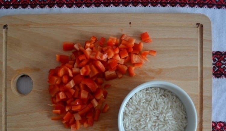 We wash the rice and cut the bell peppers into pieces.
