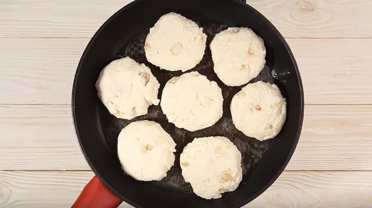 We heat the pan with vegetable oil, put the cheese cakes on it.