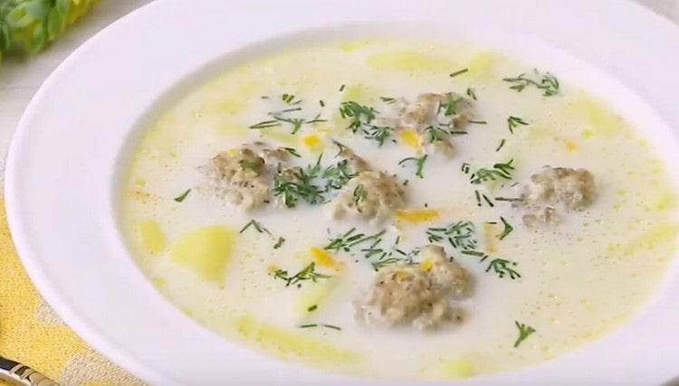 Al servir, la sopa de queso con albóndigas se puede rociar con verduras finamente picadas.