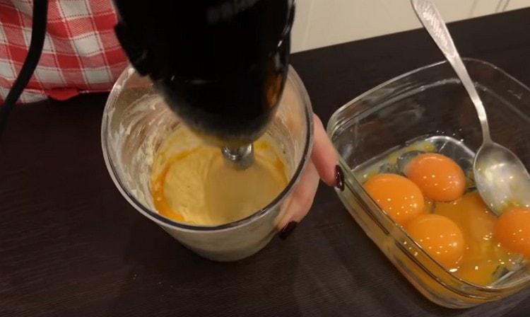 Un à la fois, introduisez les jaunes dans le beurre en fouettant la masse.