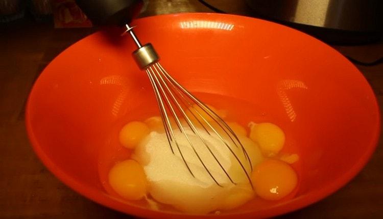 Batir los huevos con azúcar.