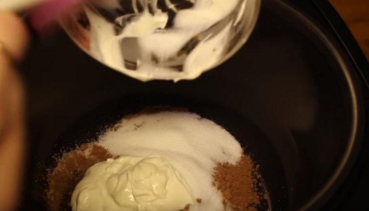 To prepare the glaze, combine sugar, cocoa and sour cream into a multicooker bowl.