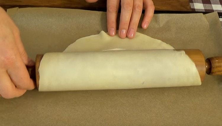 À l'aide d'un rouleau à pâtisserie, transférez délicatement la pièce sur une plaque à pâtisserie recouverte de papier sulfurisé.