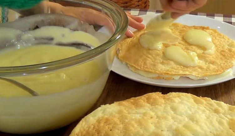 Nous collectons le gâteau en badigeonnant tous les gâteaux de crème.