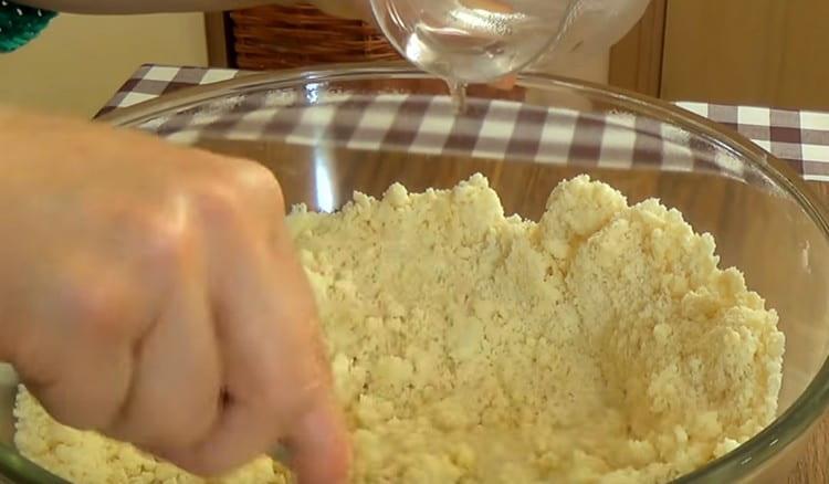 Versez de l'eau et du vinaigre dans la masse de farine et mélangez.