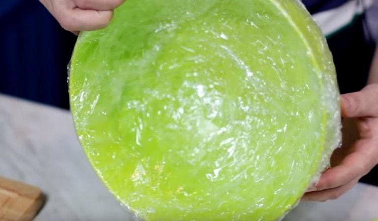 Lining a large bowl or shape with cling film.