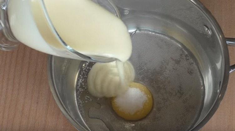 Adăugați zahăr vanilat, lapte condensat și apă pe gălbenuș.
