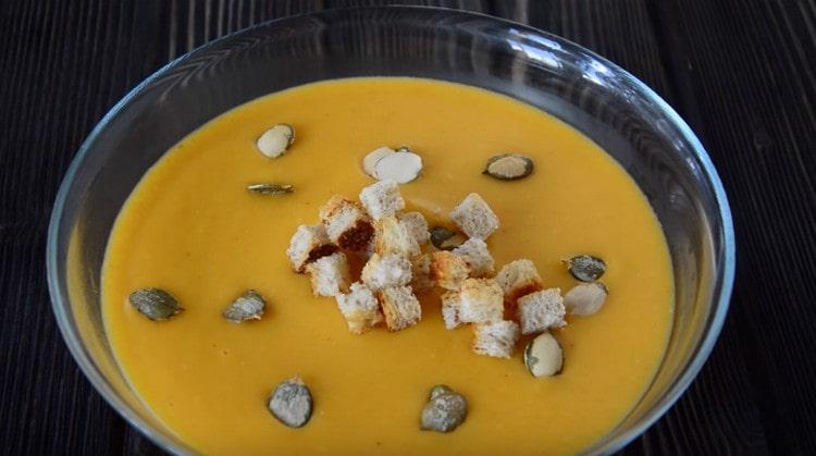 A pumpkin cream soup prepared according to the recipe with cream can be decorated with croutons and pumpkin seeds when serving.