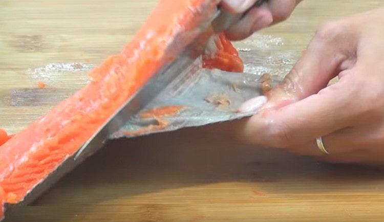 Carefully separate the fish meat from the skin.