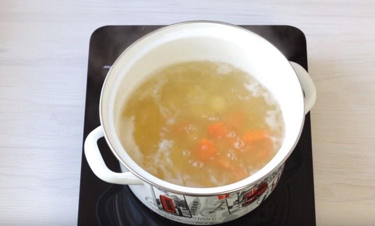 Ensuite, ajoutez les carottes hachées au bouillon.