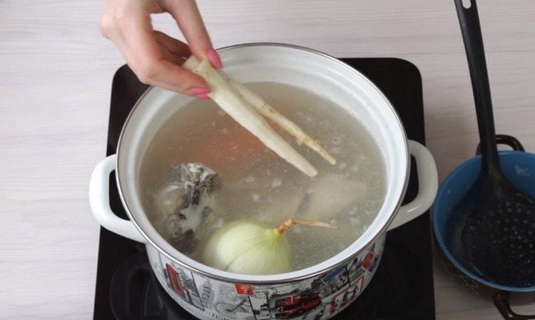 Add greens and parsley roots to the broth.