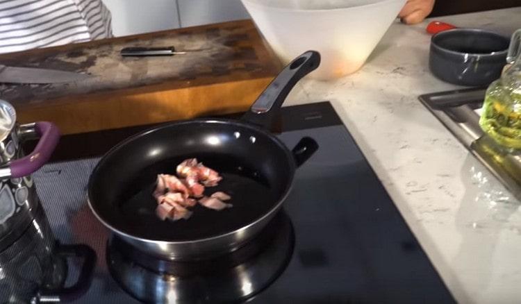 Nous étalons le bacon dans une casserole et le faisons frire pour obtenir des frites particulières.
