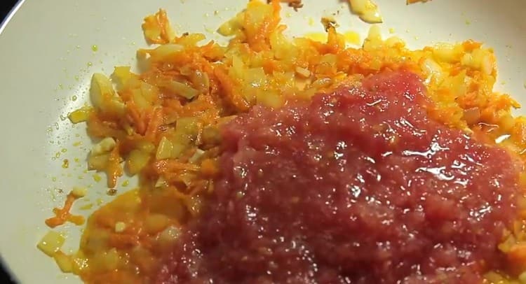 Agregue el ajo y los tomates rallados a la sartén.
