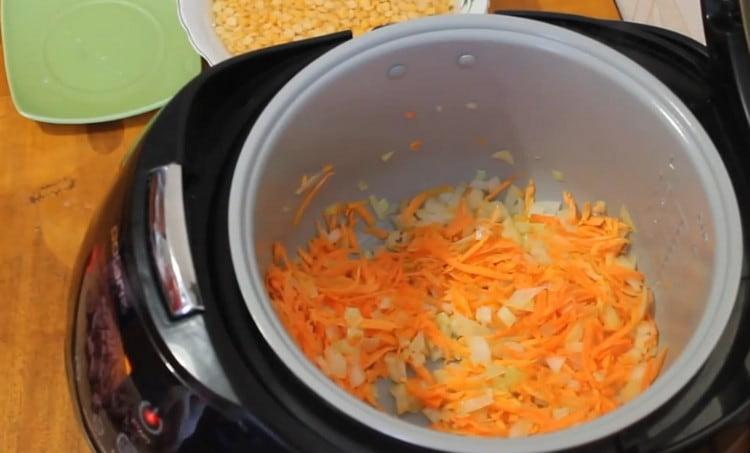 Fríe la cebolla con zanahorias en el recipiente multicocina.