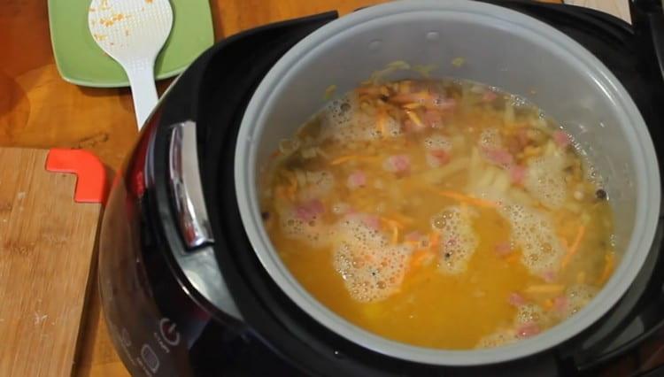 Ibuhos ang mga sangkap na may tubig at i-on ang sopas na mode ng pagluluto sa multicooker.